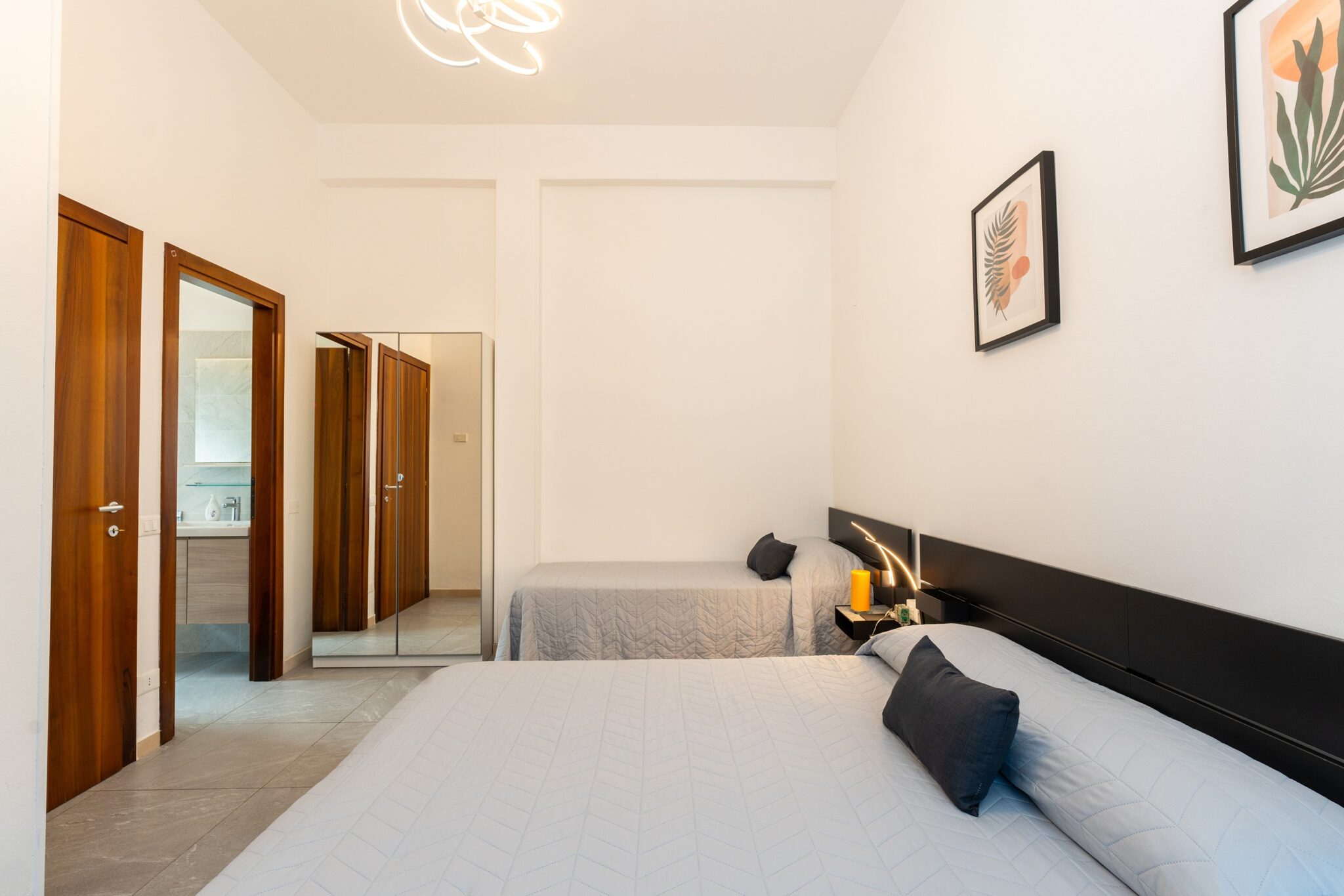 Camera da letto con un letto matrimoniale queen size e un letto singolo.